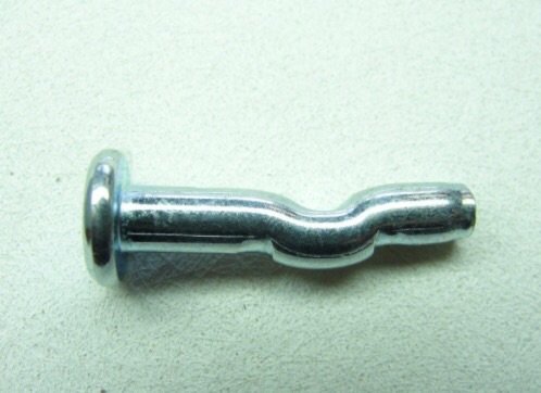 En spikplugg av metall mot en ljus bakgrund, avsedd för infästning i tak eller väggar.