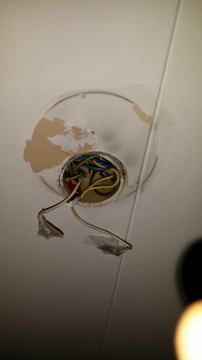 Takt med flagnande färg och elledningar där en lampa tagits ner.