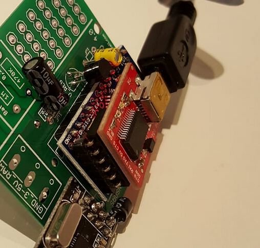 FTDI-adapter ansluten upp och ner till en Pro Mini modulkort med synliga kablar och lödningar.