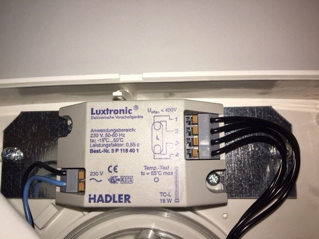 Luxtronic elektronisk voorschaltgeräte trafo för en takarmatur monterad på en vägg med synliga kablar och etiketter.