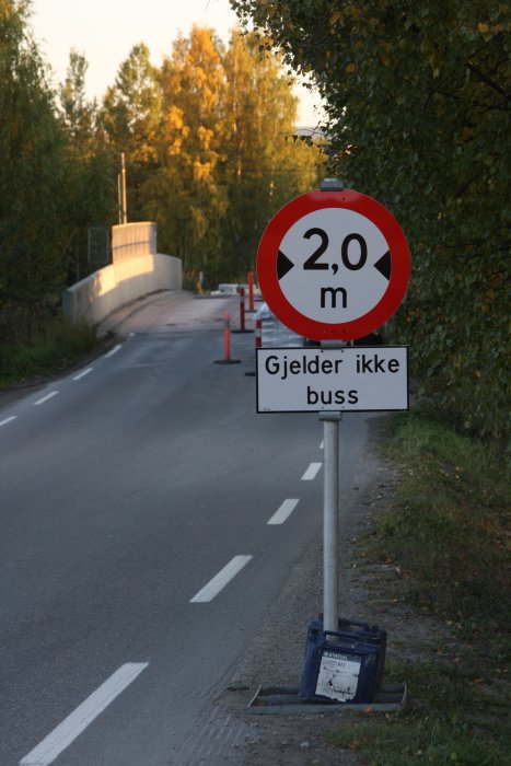 Vägskylt som visar höjdbegränsning 2,0 m med tilläggstavla "Gjelder ikke buss" vid vägarbete.