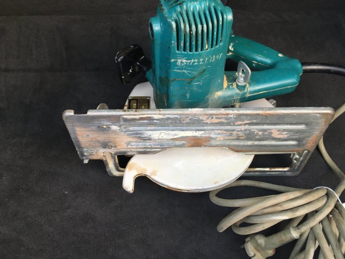 Gammal cirkelsåg med 210mm klinga och sliten vit och turkos design, utan synlig märkning.