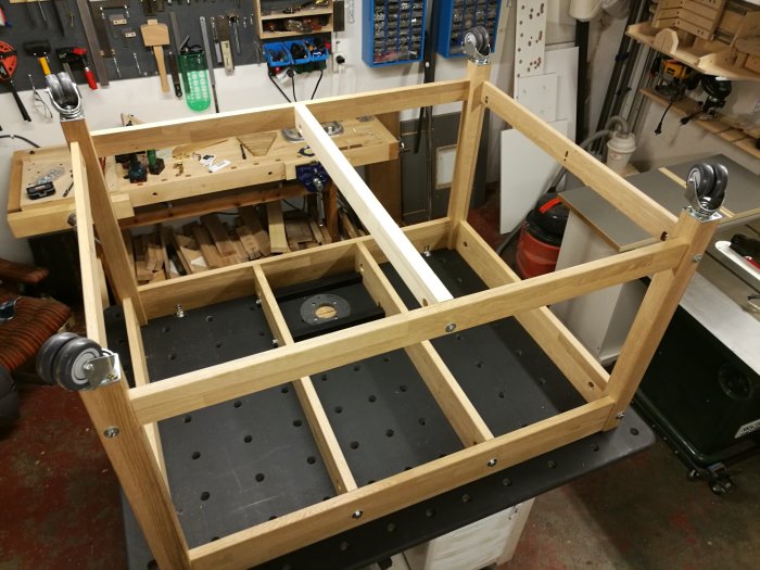 Nybyggt monterings/fräsbord med ekbänkskivsstomme och svart valchromat topp, i en verkstadsmiljö.