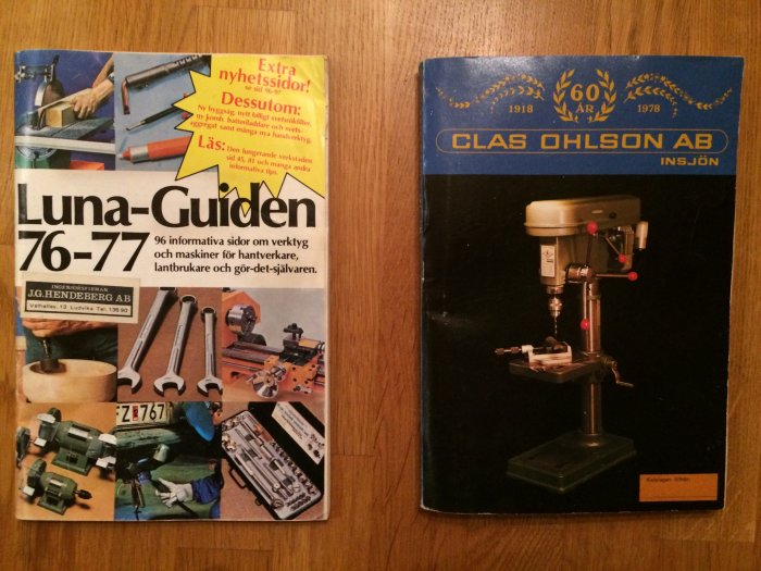 Två äldre byggvarukataloger från Luna och Clas Ohlson på ett trägolv.