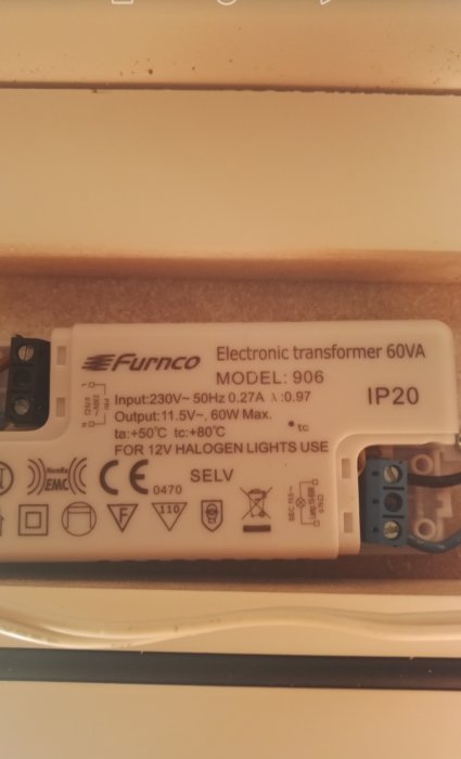 Elektronisk transformator för 12V halogenbelysning i trångt skåp, modell och specifikationer synliga.