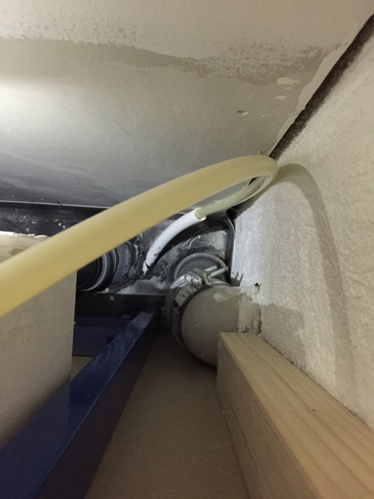 Vattenskada runt en ventilationsskarv med synlig muff och fukt under plåtbandage samt svartmögel på gipsvägg.