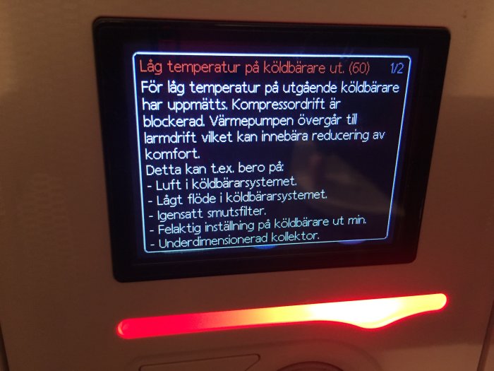 Display på en Nibe 1145 bergvärmepump visar larm för låg temperatur på utgående köldbärare.