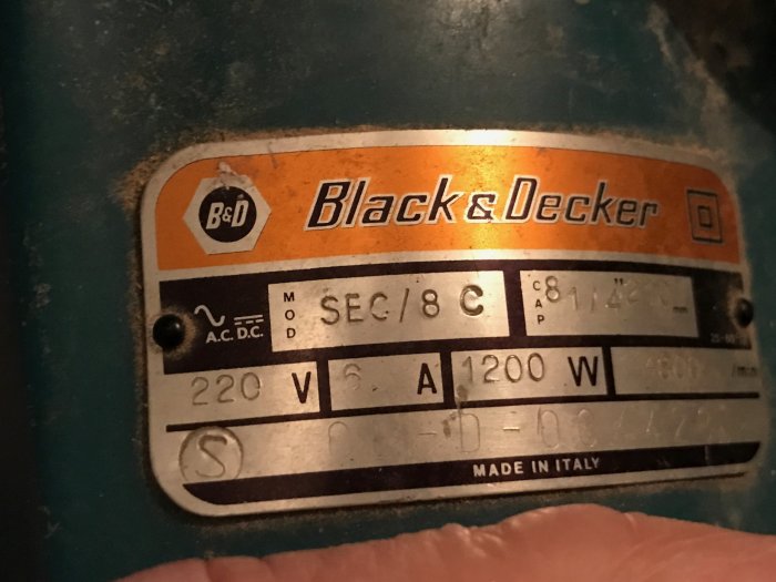 Typskylt på en Black & Decker SEC/8 C verktyg med specifikationer 220V och 1200W, sliten och smutsig.