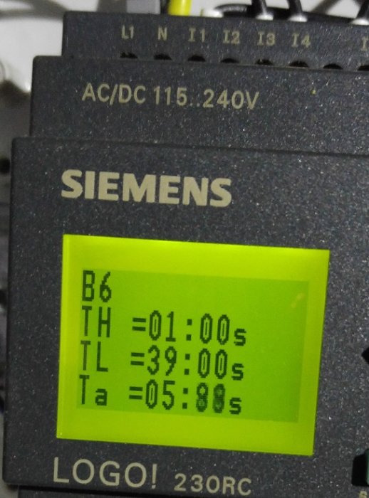 Siemens programmerbar logikstyrenhet som visar tidinställningar för start och matning av pellets.