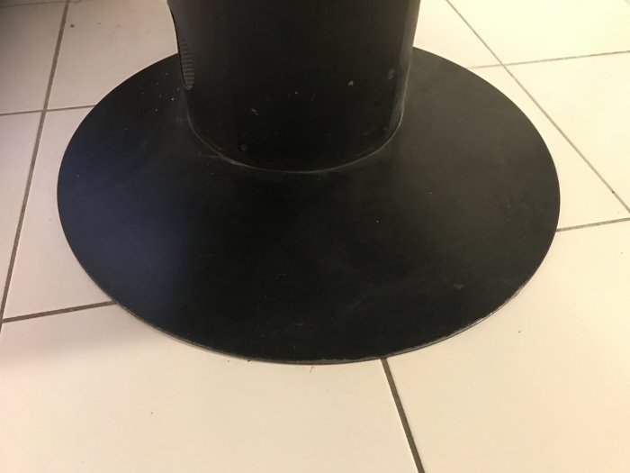 Svetsad bottenplatta på en braskamin placerad på klinkergolv.