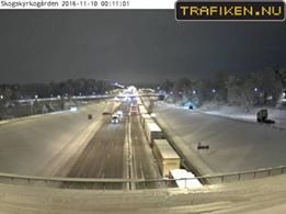 Väg 73 täckt med snö och trafik en vinterkväll i Stockholm.