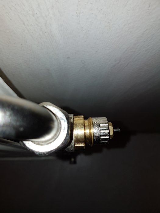 Närbild på ett radiatorventil med två reglage, ett yttre avtagbart vred och ett inre hjul.