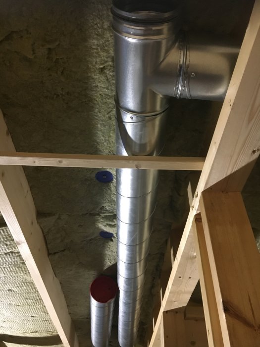 Ventilationsrör och isolerad ull i ett trästomme vid en husrenovering.