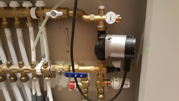 Uponor Push 23 värmefördelare med röd och grå flödesratt för returledning och mätinstrument.