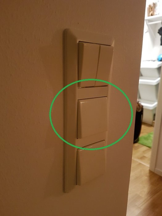 Väggmonterad ljusbrytare markerad med grön cirkel för installering av dosdimmer.