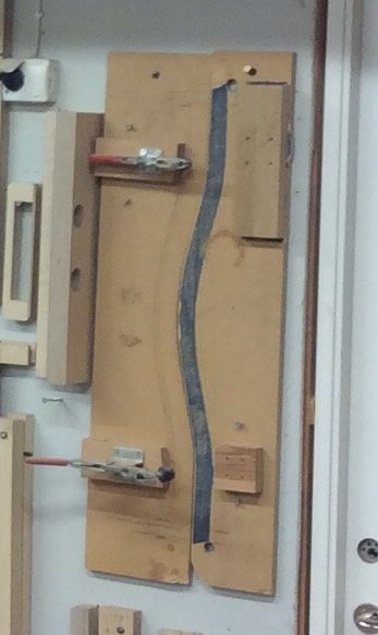 Mallar för fräsning fastsatta på en verkstadsvägg, inklusive ytter- och innermall för porthandtag.