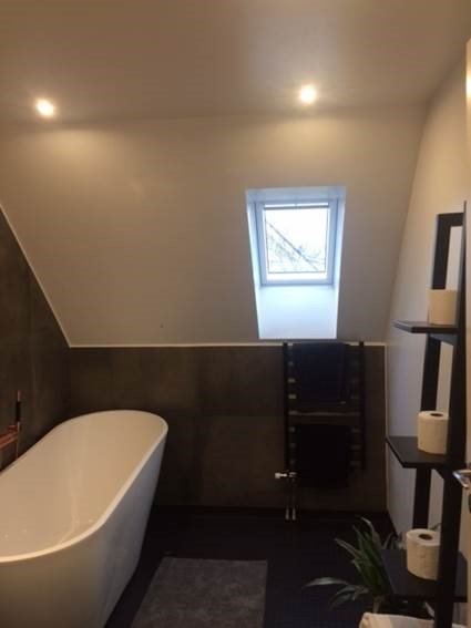 Renoverat badrum med frittstående badkar, handdukstork och takfönster, diskussion om placering och installation.