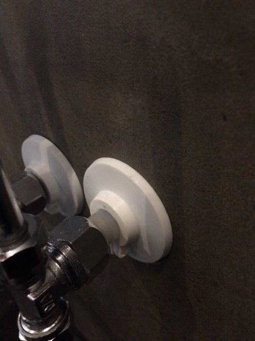 Rörinstallation med pexslang och skyddsrör i vägg, synliga manchetter och anslutningsdetaljer.