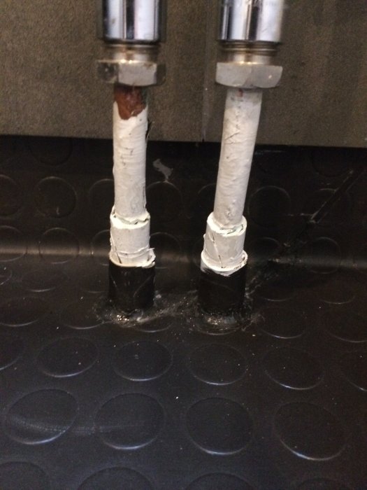 Pexslang i skyddsrör genomgår en installation med synliga manchetter och tätning, mot en mörk bakgrund.