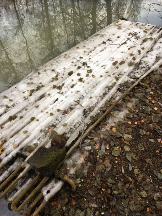 Snötäckt värmepump utomhus med löv och grenar; användare har rensat för effektivitet.