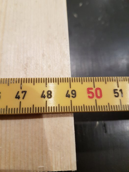 Måttband som visar 50 centimeter vid en träregel som förbereds för gjutform av bänkskiva.