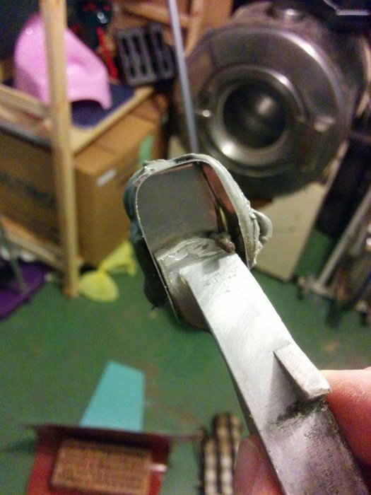 Närbild av aluminiumdel med spricka lagad med zinklödning, i en verkstadsmiljö.