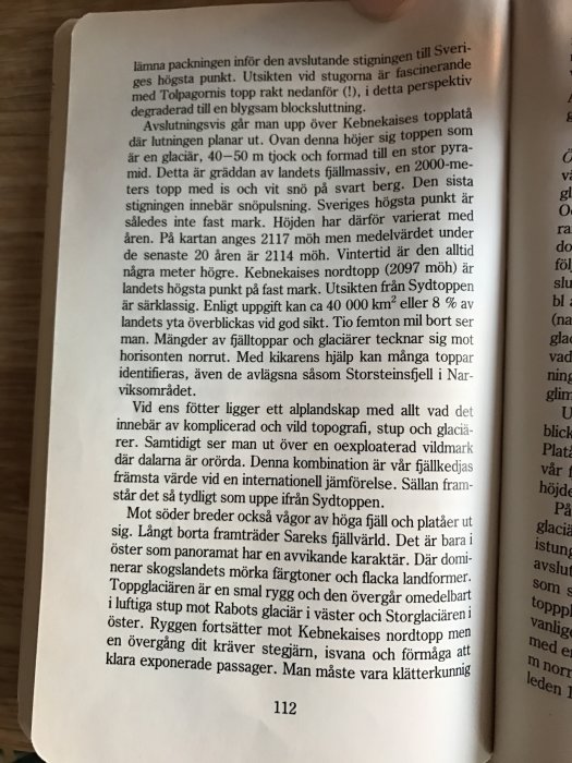 Ett uppslag ur boken "På fjälltur" med beskrivning av fjällvandring, text synlig på sidan 112 med fokus på fjälltoppen och rutter.
