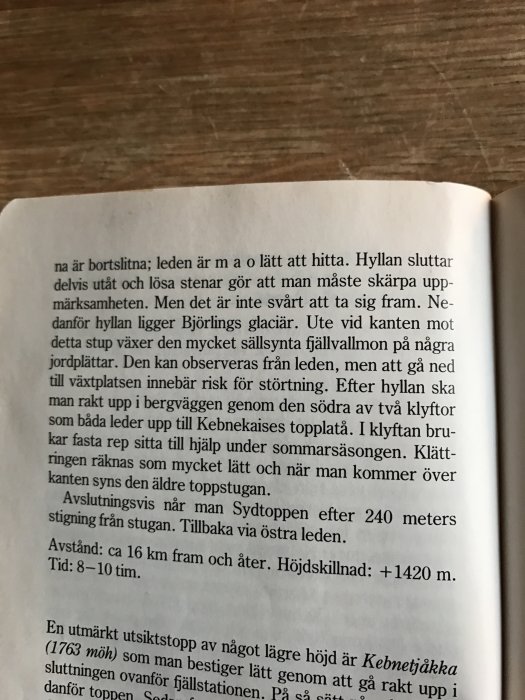 Bild på en uppslagen bok med text om en fjälltur och dess rutter, tagningsviss och tidsåtgång.