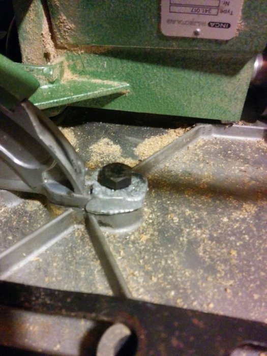 Smält zink i form med cykeleker på en arbetsbänk, omgiven av metallspån och verktyg.