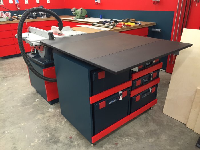 Svart och blått arbetsbord med L-Boxx förvaring och flyttbara björkplywoodhyllplan i ett verkstadsutrymme.