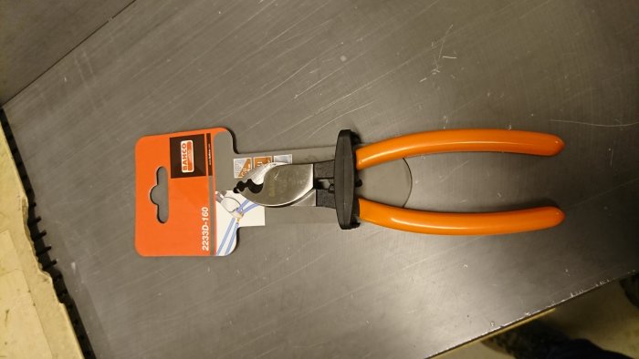 Bahco kabelsax med orange handtag på Jula-förpackning liggande på en arbetsbänk.