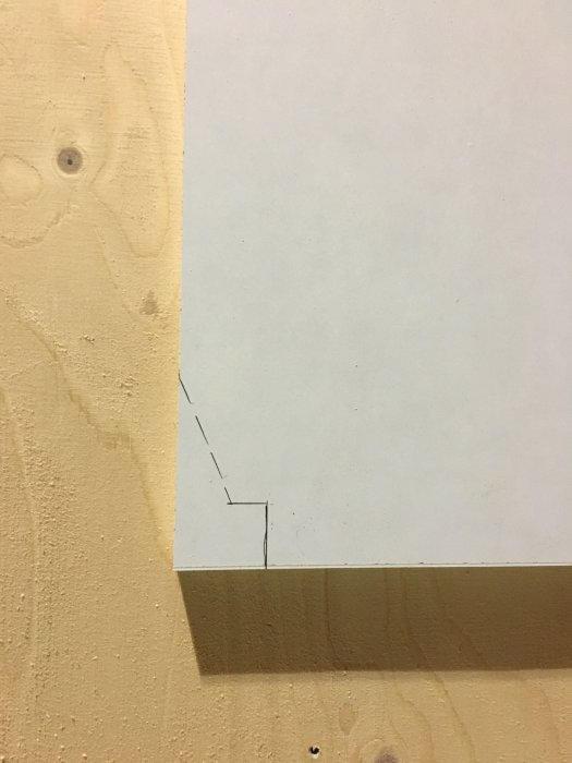 MDF-skiva med markerad ursparningslinje och streckad linje för dold snittsektion mot en träbakgrund.