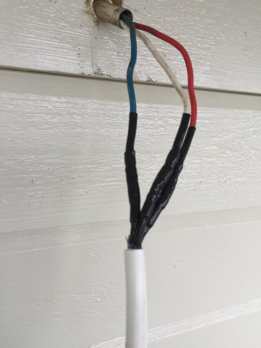 Elektriska kablar med krympslang på en skarv vid montering av balkonglampa.