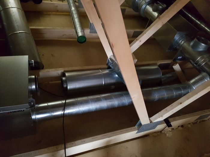 Ventilationskanaler och en del av ett ventilationsaggregat monterade i ett byggstomme.