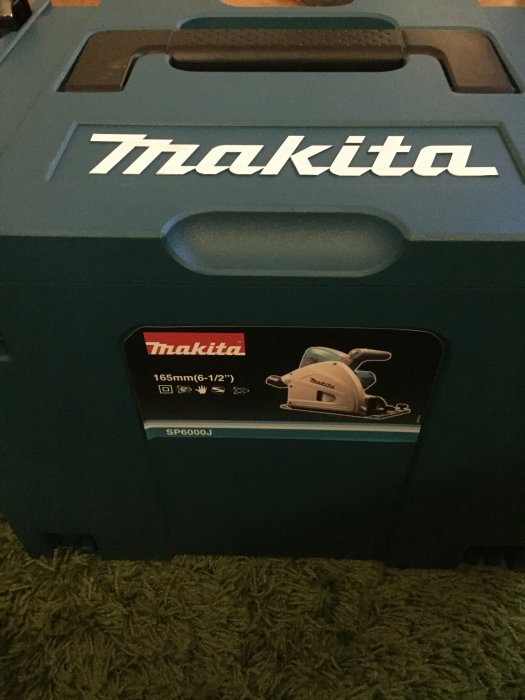 Ny Makita cirkelsågsförpackning på ett grönt golv, ej använd än.