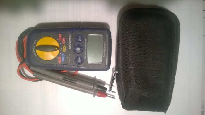 Digital multimeter av modellen Sagab DMM-904 med inbyggda mätledningar bredvid en svart förvaringspåse.