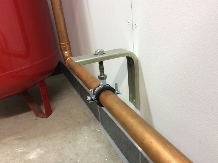 Kopparledning och rördelar installerade vid ett rödvärmesystem, med fokus på laddomatens anslutning.