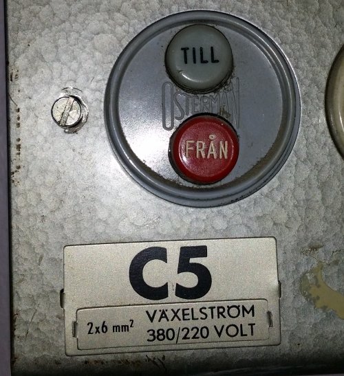 Närbild av en äldre elcentral med en etikett märkt "C5 VÄXELSTRÖM 380/220 VOLT", 2x6 mm2, samt till/från vippströmbrytare.