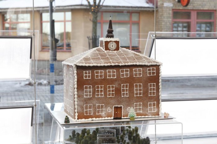 Pepparkakshus i form av ett stort hus med detaljer placerat på en glasskiva.