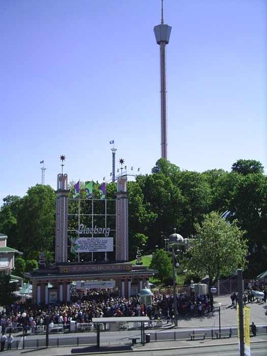 Vy över Liseberg med AtmosFear-tornet och en folkmassa vid huvudentrén.