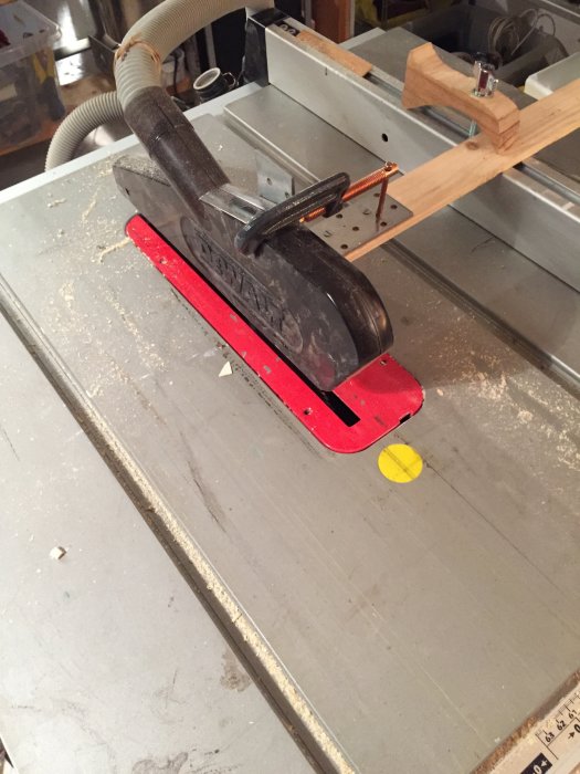 Modifierat klingskydd på en bordsåg med en hemmagjord träarm för justering av skyddets höjd.