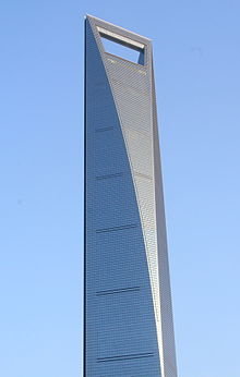 Bild av det höga byggnadsverket Shanghai World Financial Center mot en klarblå himmel.