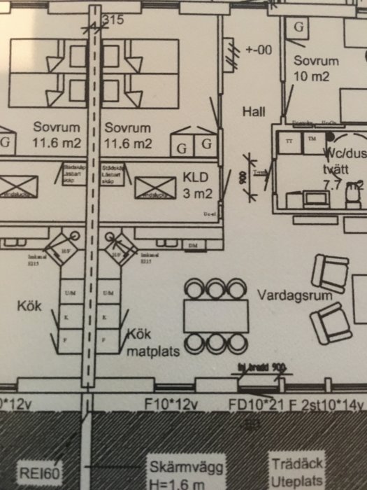 Ritning av en bostadsplanslösning med markerade kök och matplats samt sovrum och vardagsrum.