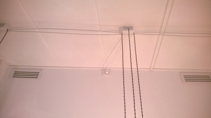 Vitt tak med synliga kablar, moderna detaljer och klassisk taklister från en byggnad i Malmö.