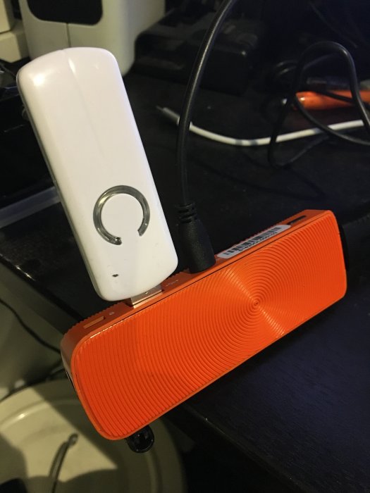 Orange mini PC med vit dongel inkopplad, använd för att köra domoticz testsetup.