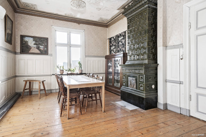 Traditionellt matrum i vacker villa med gammaldags kakelugn, trägolv och stuckatur i taket från 1900-talet.