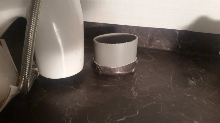 Ett 110 mm avloppsrör uppvikt med plastmatta i en badrumsrenovering, där toaletten inte passar.