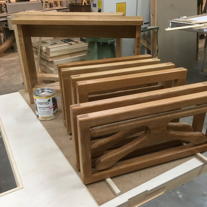 Trädelar av vägghängda herrbetjänter på arbetsbänk med burk av hårdvaxolja.