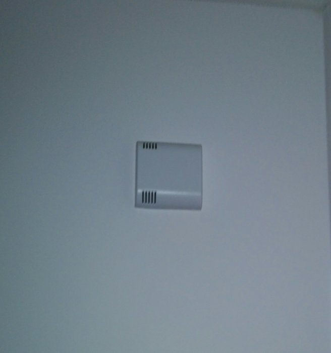 Thermostat för temperaturmätning på vägg i sovrum med ventilationssystem.