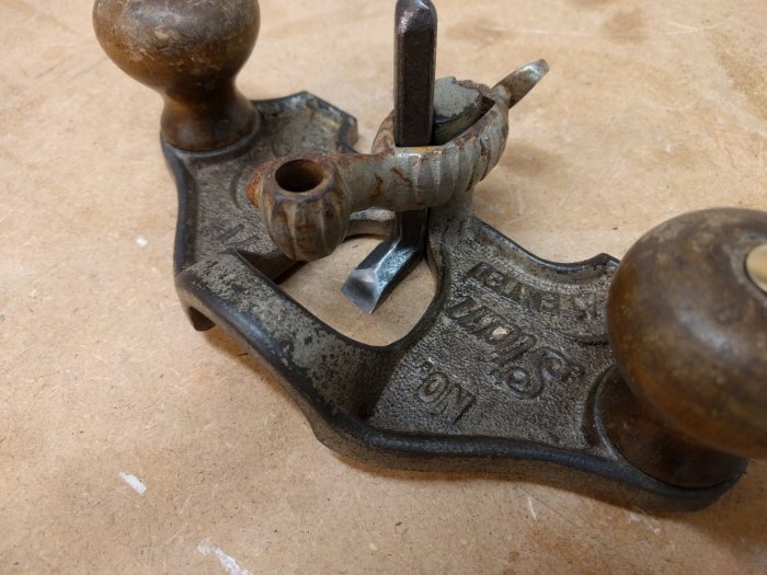 Antik Stanley 71 handöverfräs med synliga tecken på åldring och rost, framför träbänk.